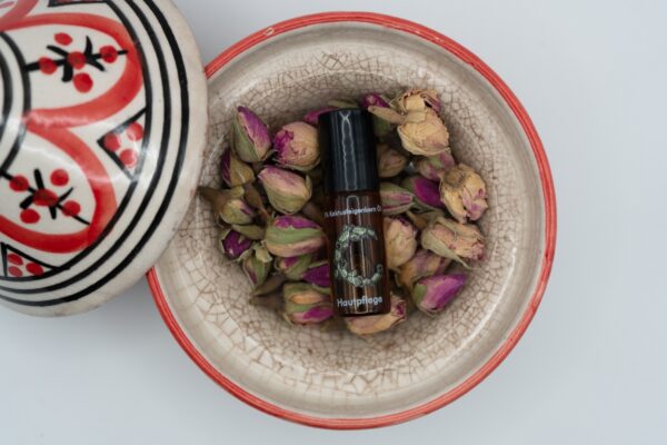 Noils Cactus Oil Flasche in Schale mit getrockneten Rosenknospen