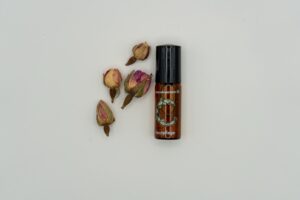 Noils Cactus Oil Roll-On 2 ml, dekoriert mit getrockneten Rosenknospen auf hellem Hintergrund