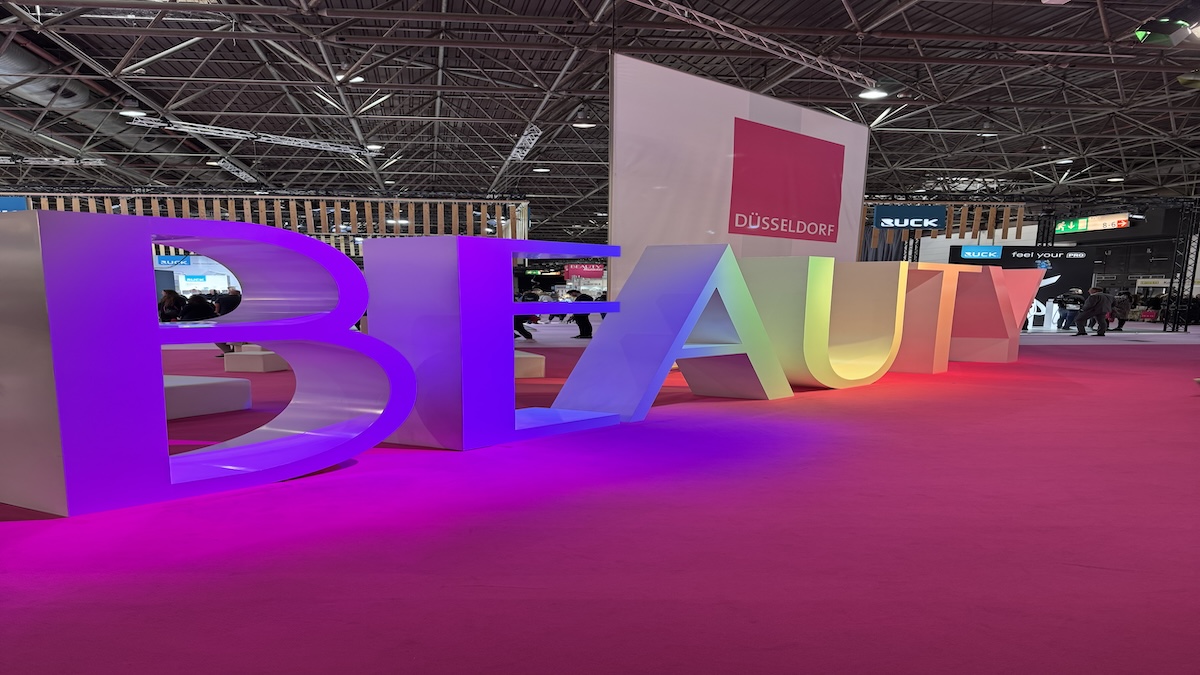 Große, farbige beleuchtete Buchstaben `BEAUTY`am Eingang der messe Düsseldorf. Moderner, weitläufiger Messebereich mit klarer Architektur un d freundlicher Atmosphäre,